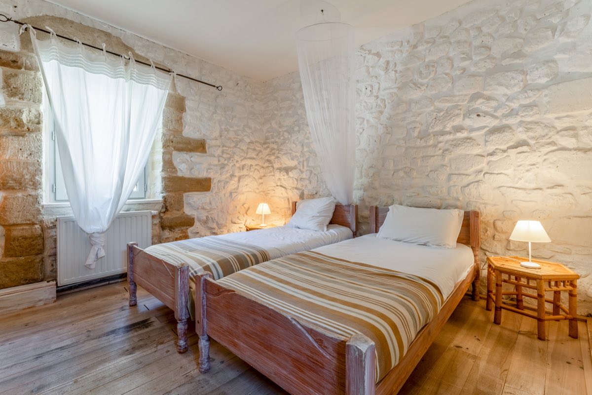 Chambre à deux lits du Mas de Rey, murs en pierre apparente
